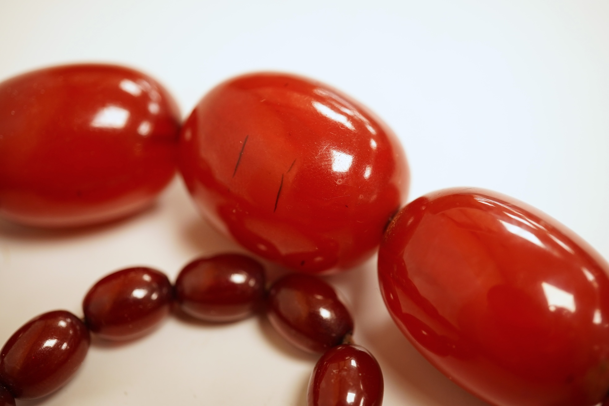 A single strand graduated simulated cherry amber bead necklace, 76cm, gross weight 75 grams.